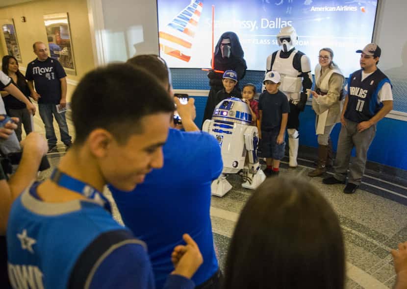 Dallas Mavericks fans pose with actors dressed up like Star Wars characters on the concourse...