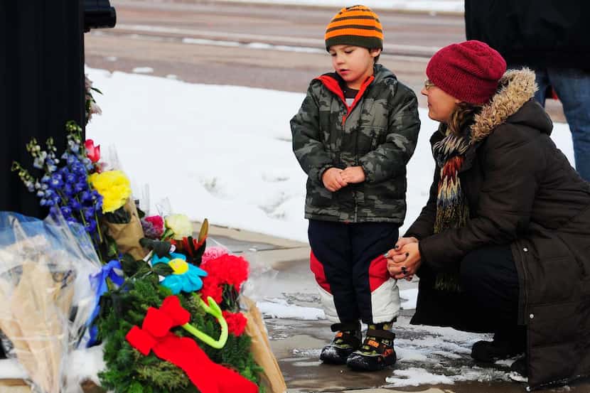 
Korbyn Fair and his mother, Nasya, say a prayer Sunday at the memorial in Colorado Springs...