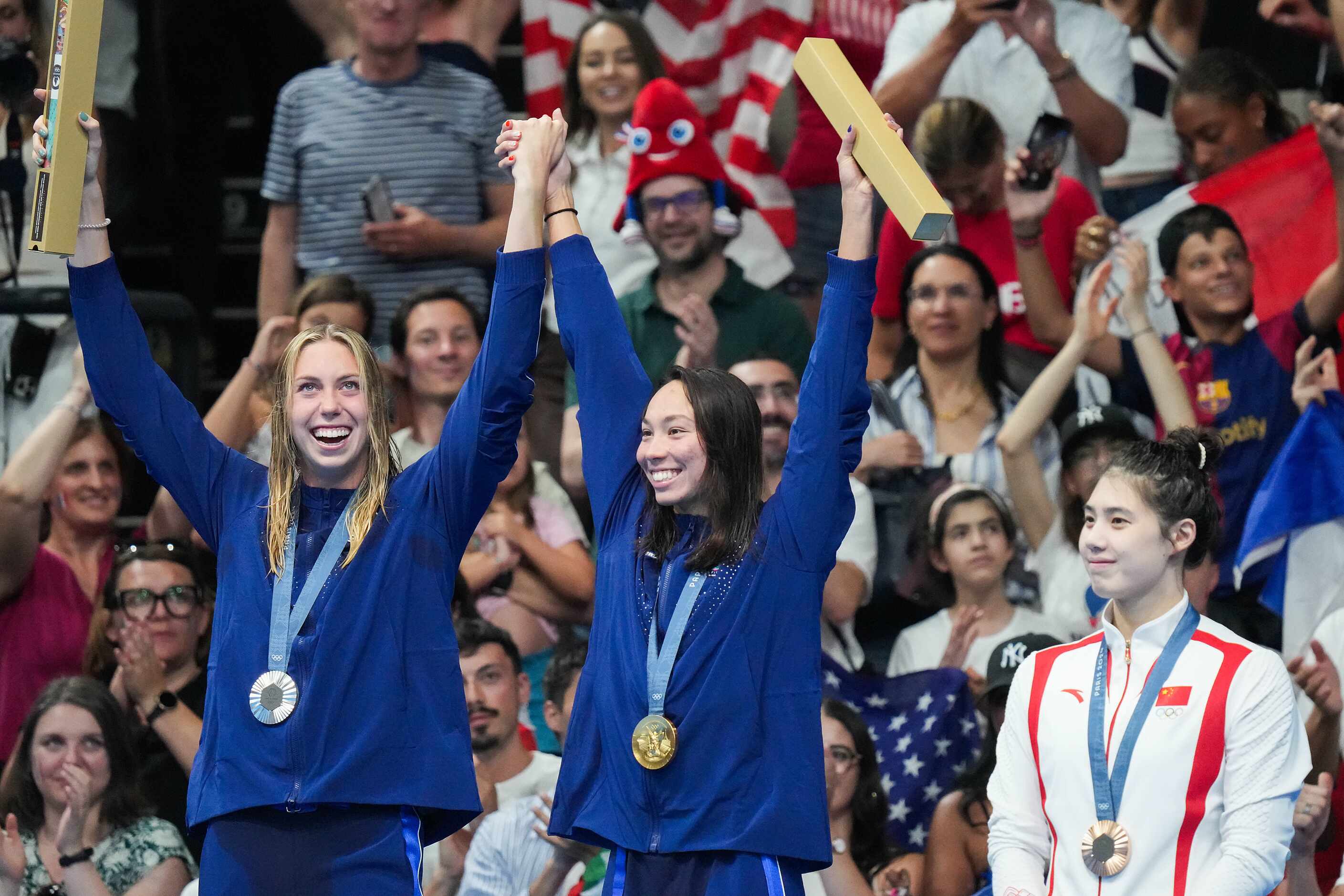 Gold medalist Torri Huske of the United States (center) celebrates on the podium with silver...