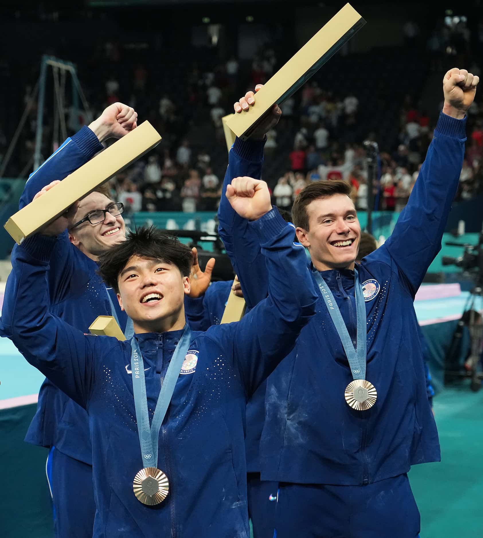 Asher Hong of the United States celebrates with Stephen Nedoroscik (back left) and Brody...