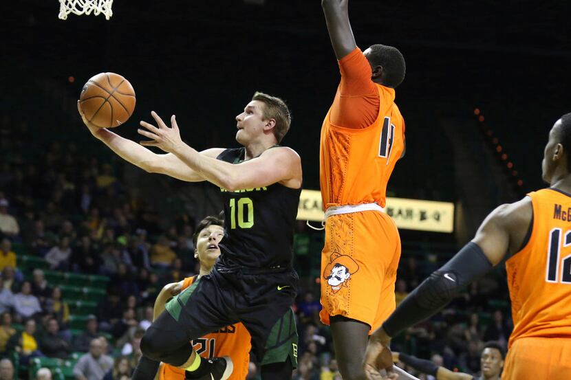 Baylor guard Makai Mason, left, drives and scores past Oklahoma State forward Yor Anei,...