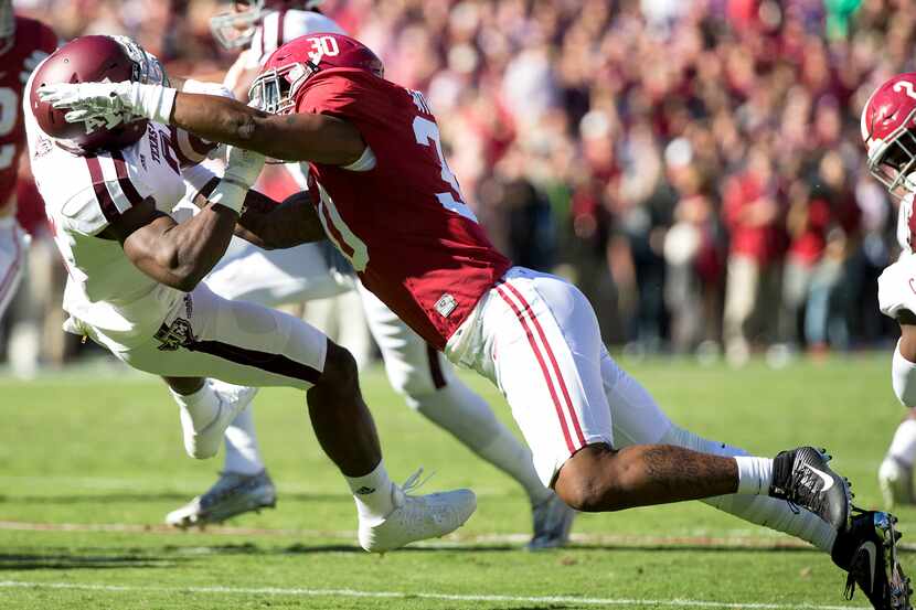 Texas A&M wide receiver Speedy Noil (2) is hit hard and laid out by Alabama linebacker Mack...