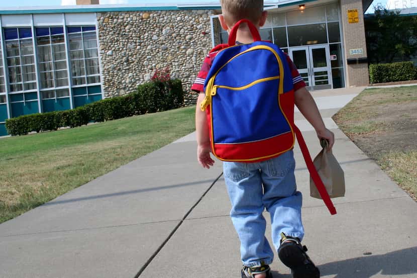 Un niño se alista para ingresar a la escuela en el primer día del ciclo escolar.