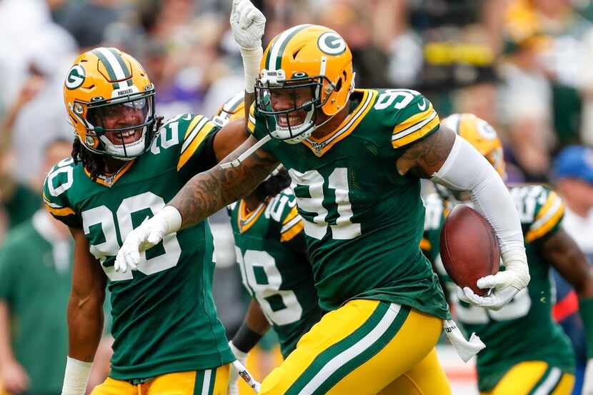 Green Bay Packers' Preston Smith celebrates after intercepting a pass during the first half...