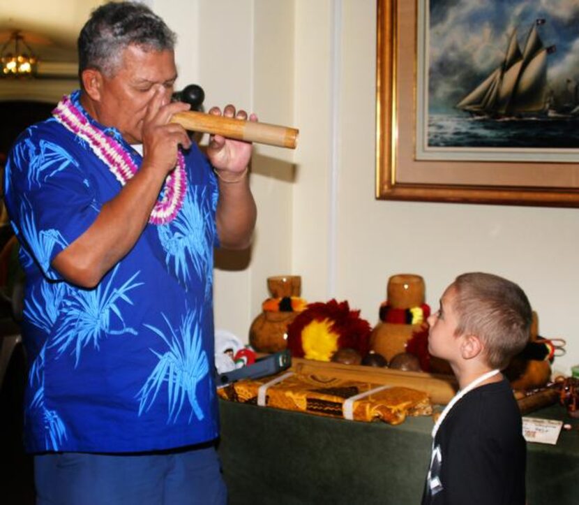 
A native Hawaiian’s nose flute performance fascinates a visiting boy.
