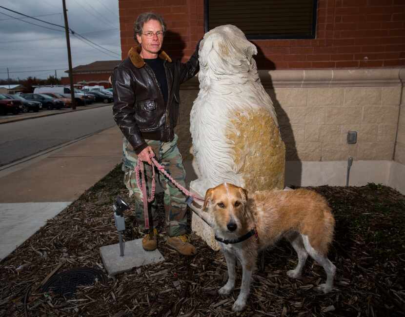 Artist Jake Dobscha poses with his sculpture, "The Watchdog," and his dog on Wednesday,...