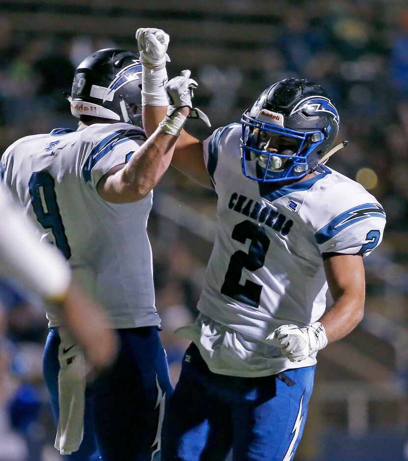 Dallas Christian's Marcus Knox (2) and Palmer Nix (9) celebrate after their team stops the...