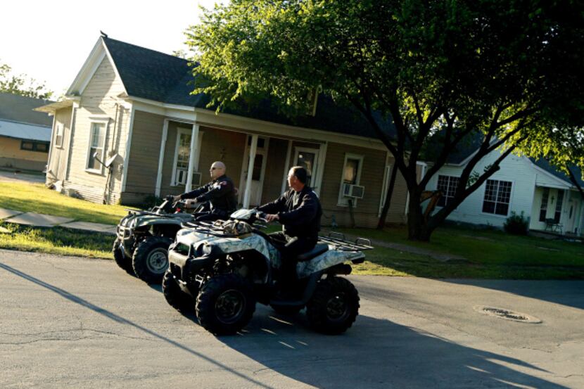 Police officers use all terrain vehicles to drive down Marable Street on Saturday, in West....