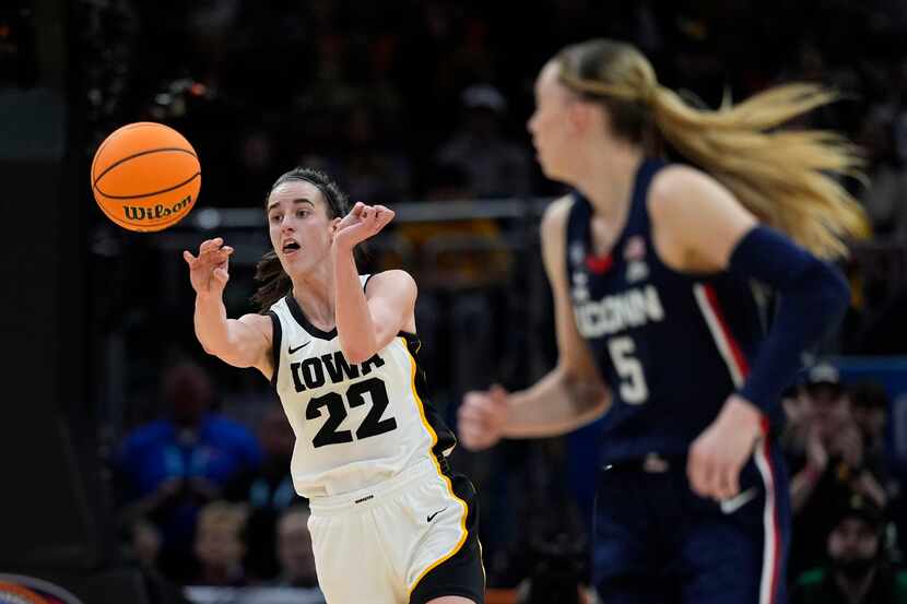 Iowa guard Caitlin Clark (22) passes up court in front of UConn guard Paige Bueckers (5)...