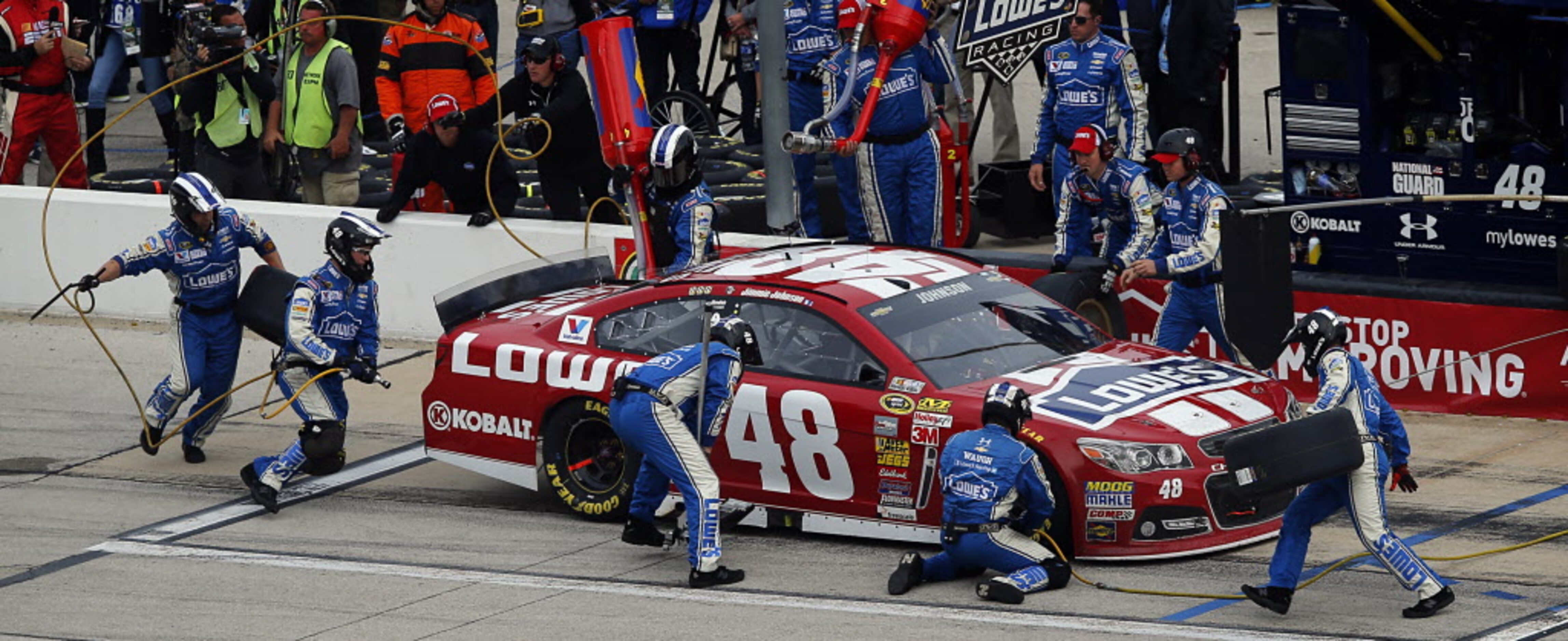 Sprint Cup Series driver Jimmie Johnson (48) receives a four-tire change during a pit stop...