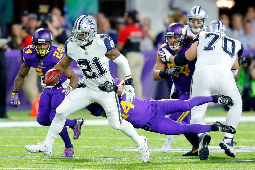 Dallas Cowboys running back Ezekiel Elliott (21) is dragged down by Minnesota Vikings strong...