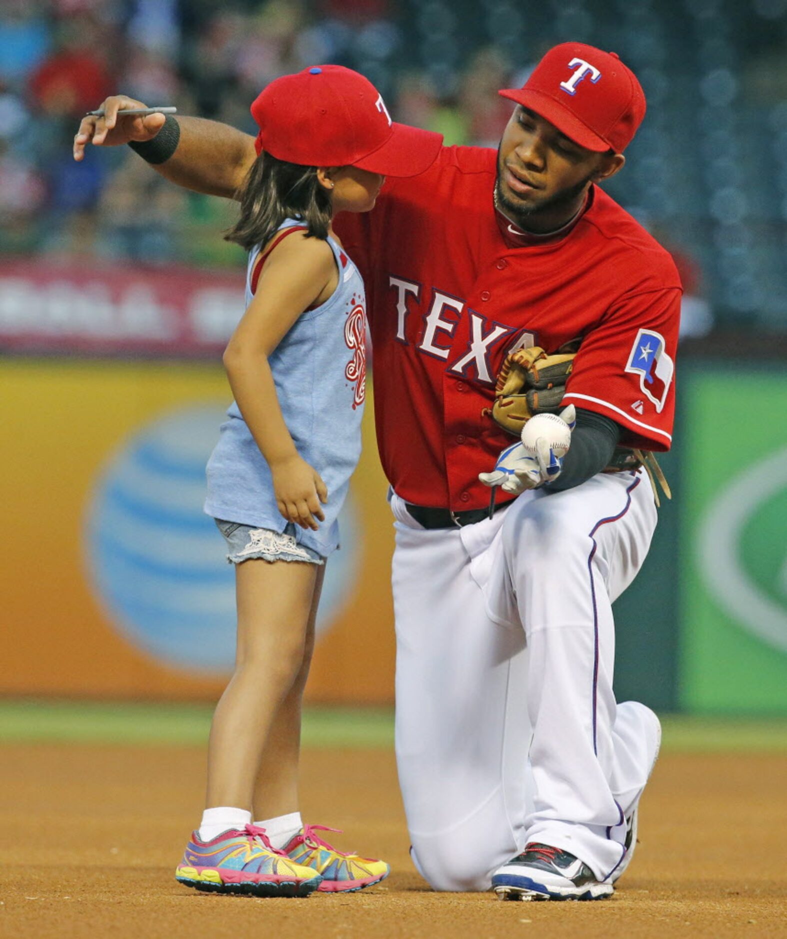 Texas shortstop Elvis Andrus gives a hug to a youngster who was waiting at the shortstop...