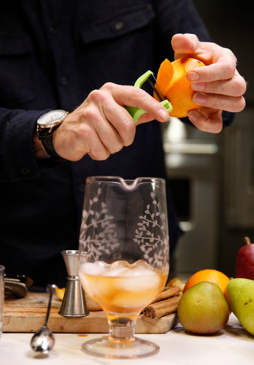 Alex Fletcher, beverage director of the Dog and Pony Show Texas peels an orange for a...