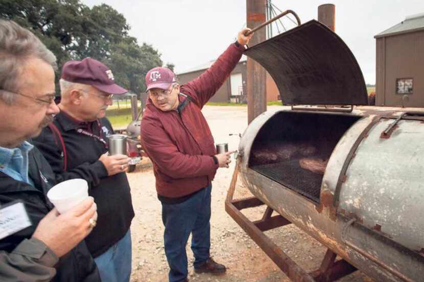 As Texas A&M professor Davey Griffin demonstrates, frequent monitoring of the smoker is part...