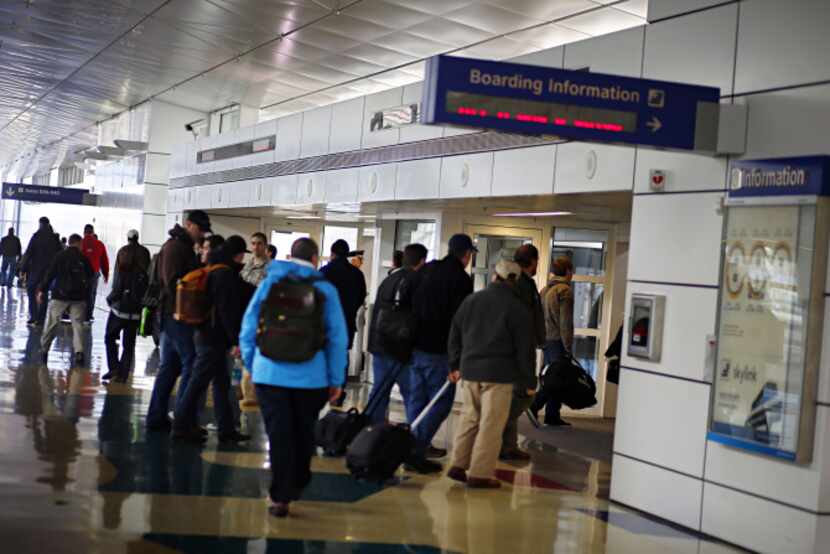 Passengers board a Skylink train at Terminal D. The trains replaced the futuristic but balky...
