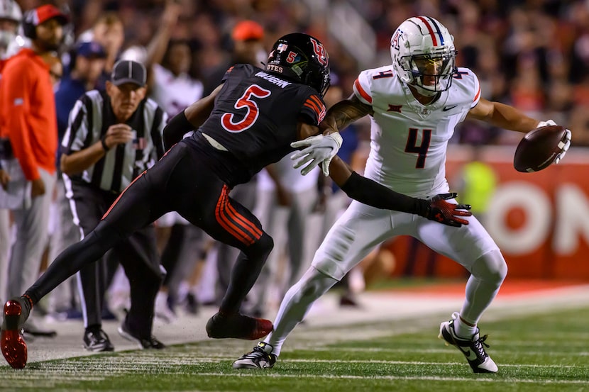 Arizona wide receiver Tetairoa McMillan (4) makes the catch and pushes away Utah cornerback...