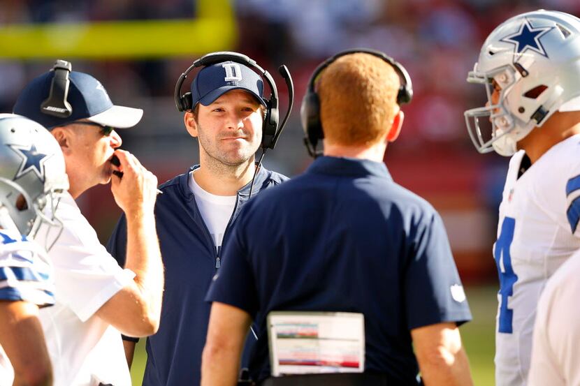 Dallas Cowboys injured quarterback Tony Romo (center) listens to head coach Jason Garrett...