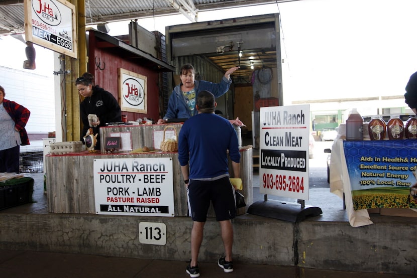 Volunteer Tori Villarreal, top, right, talks with a customer at the JuHa Ranch stand at the...