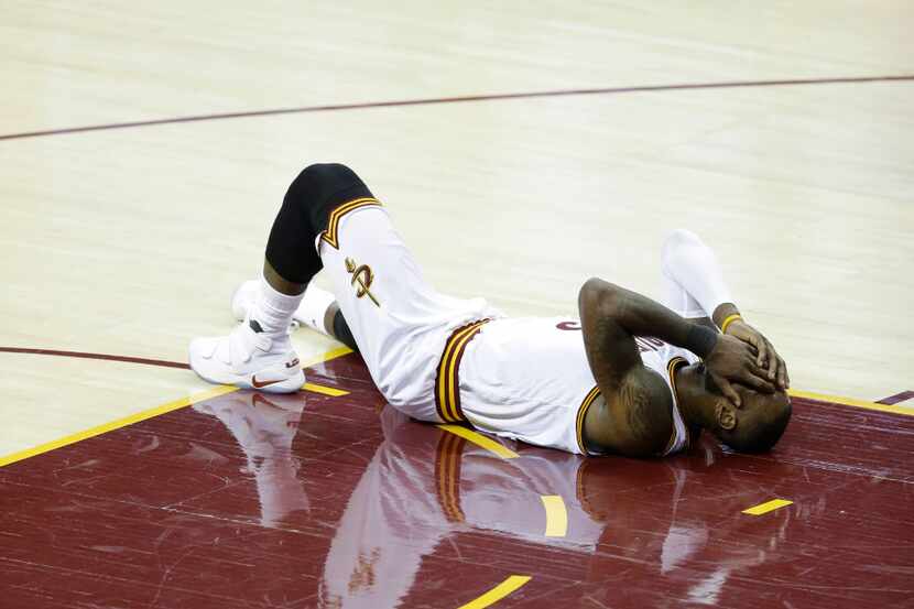 Cleveland Cavaliers forward LeBron James reacts after being injured against the Golden State...