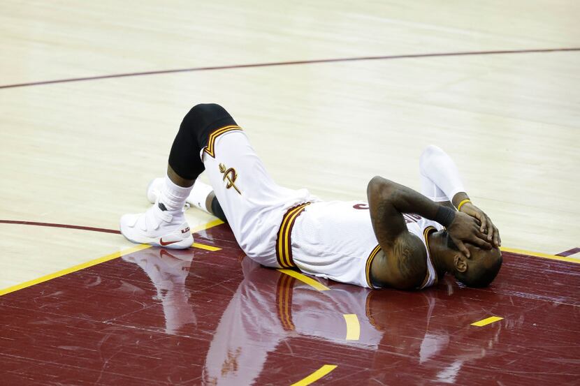 Cleveland Cavaliers forward LeBron James reacts after being injured against the Golden State...