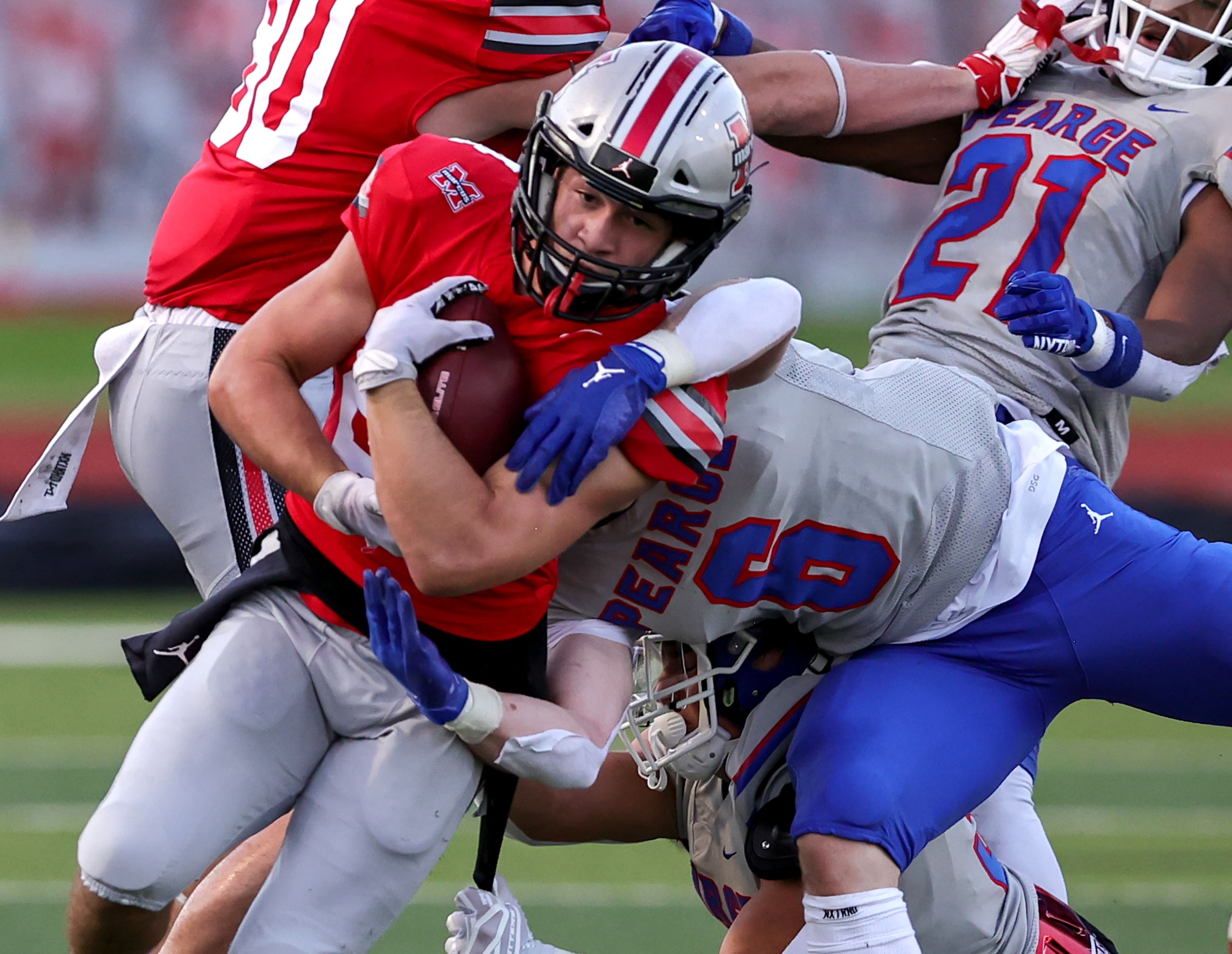 Flower Mound Marcus running back Isaiah Keliikipi (24) fights off a tackle from Richardson...