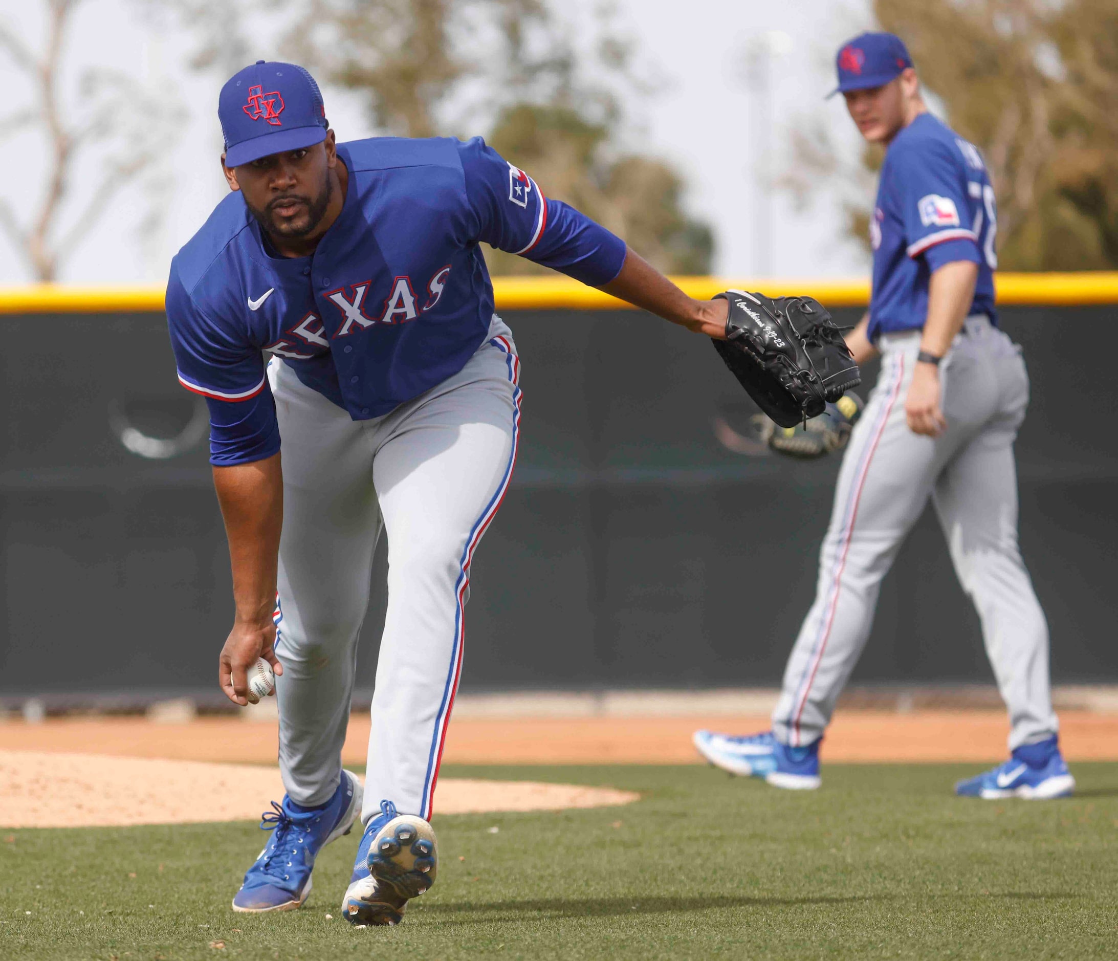 Texas Ranger pitcher Kumar Rocker takes part in a drill during a spring training workout at...