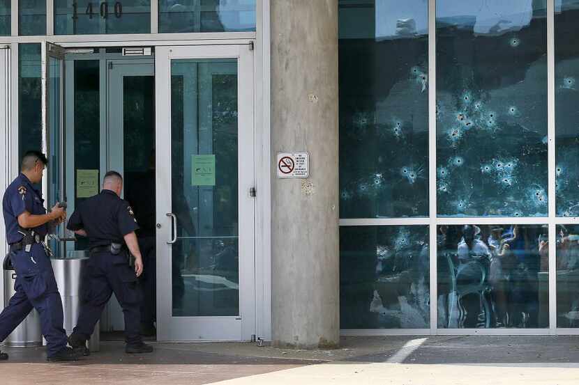 Bullet holes pierce the side of the Dallas Police Headquarters after a gunman opened fire on...
