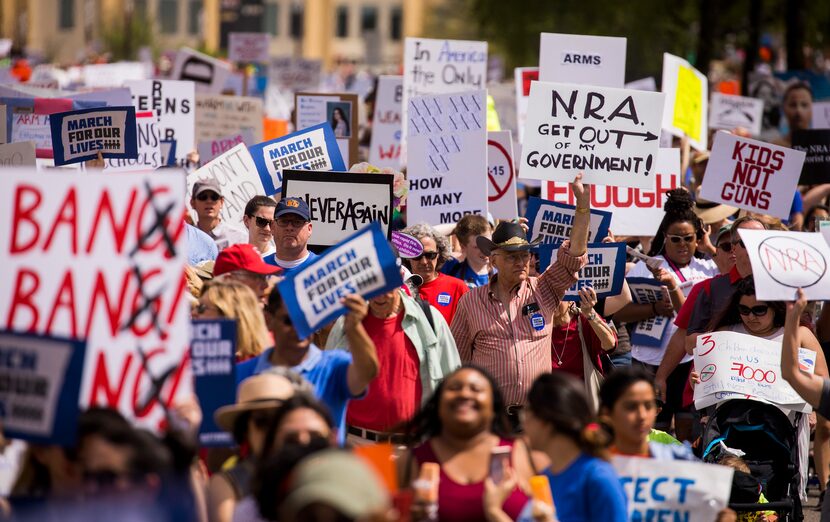 Demonstrators march down Young Street near City Hall during a rally and march in support of...