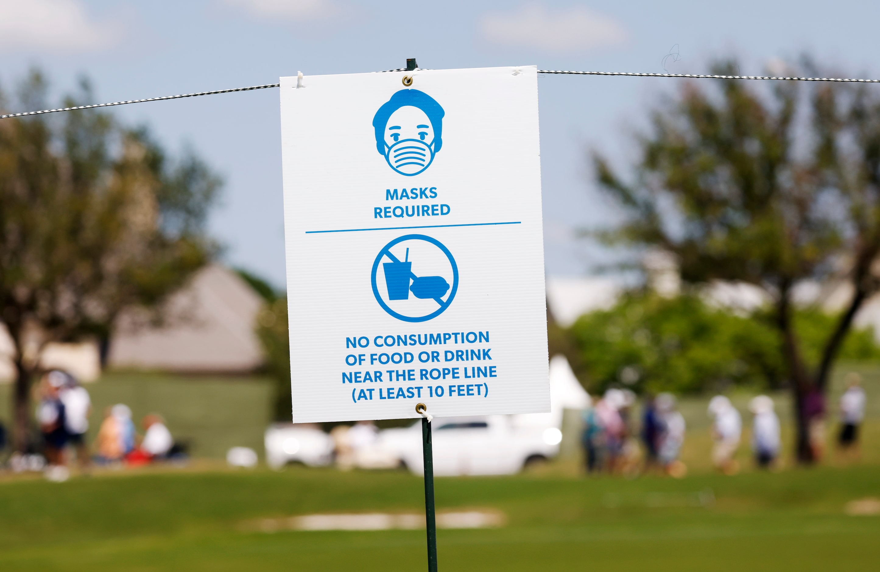 A sign alerting fans to wear masks and refrain from eating and drinking near the rope line...