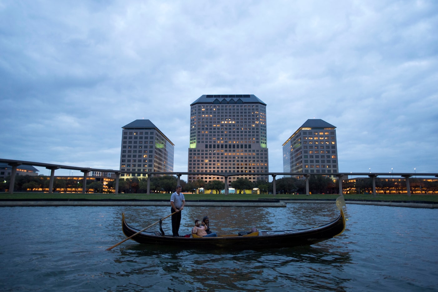 A gondolier rows his gondola across Las Colinas' Lake Carolyn as The Towers at Williams...