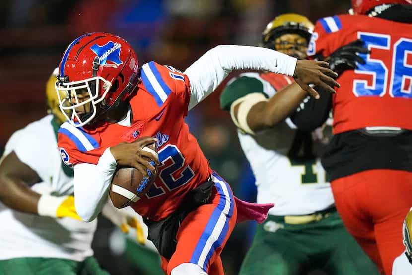 Duncanville quarterback Keelon Russell (12) scrambles away from the DeSoto pass rush during...