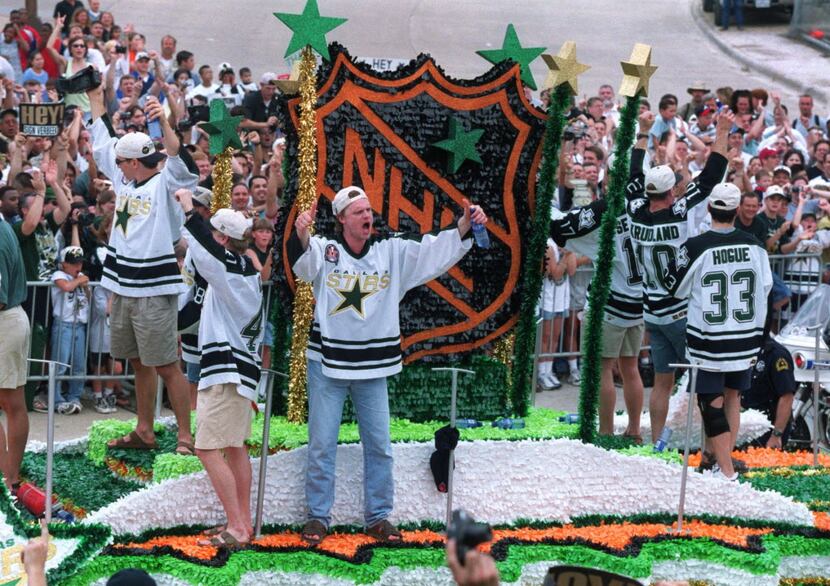 Dallas Stars goalie Roman Turek (center) pumps up  the crowd from atop an NHL float in the...