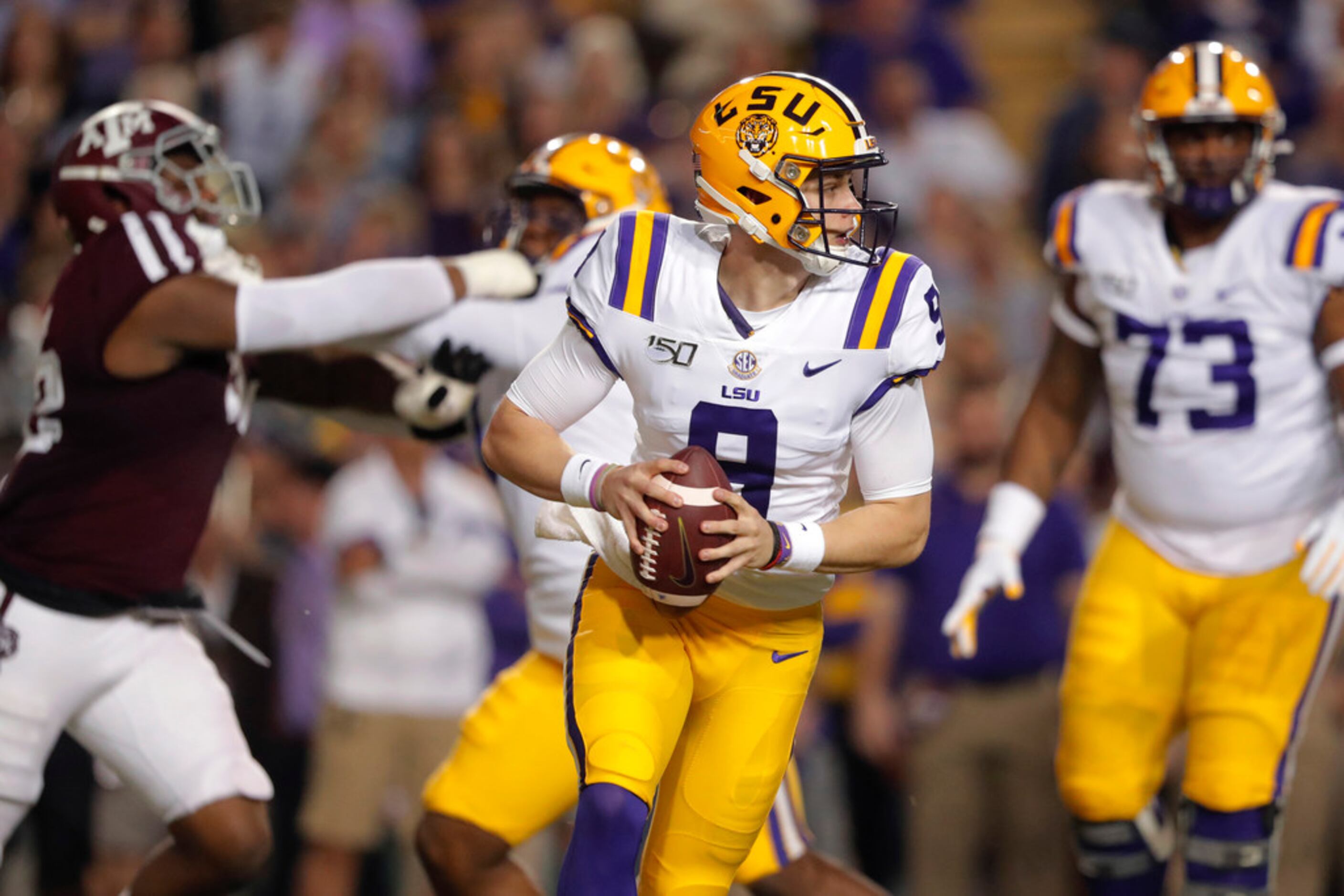 LSU quarterback Joe Burrow (9) looks for a receiver during the first half of the team's NCAA...