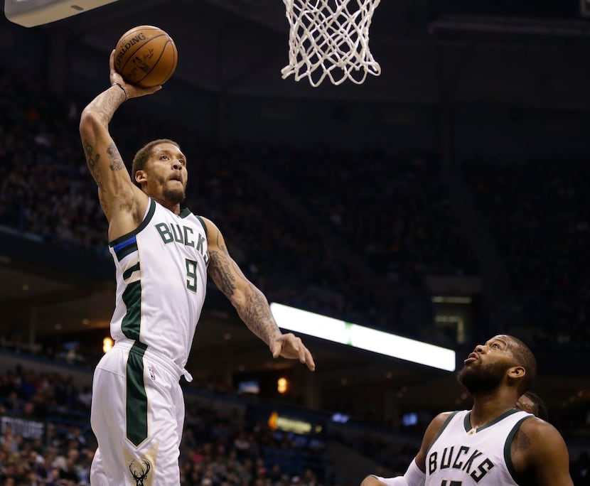 Milwaukee Bucks' Michael Beasley (9) dunks against the Boston Celtics as teammate Greg...