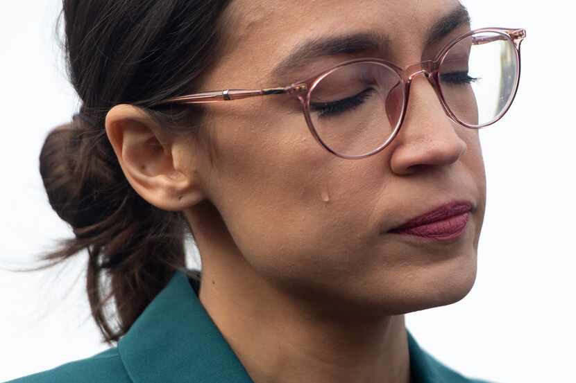 U.S. Rep. Alexandria Ocasio-Cortez, D-N.Y., sheds a tear during a press conference calling...