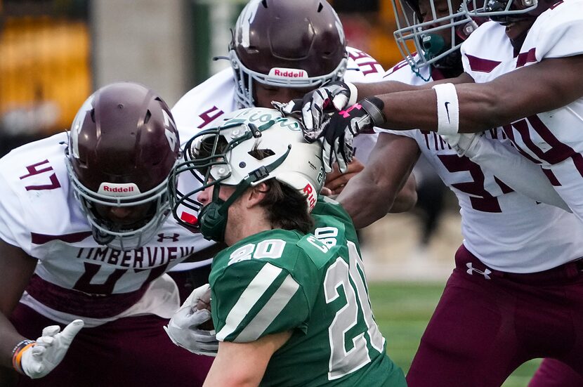 Frisco Reedy’s Cooper Clabo (20) is brought down by Mansfield Timberview’s Joseph Foster...