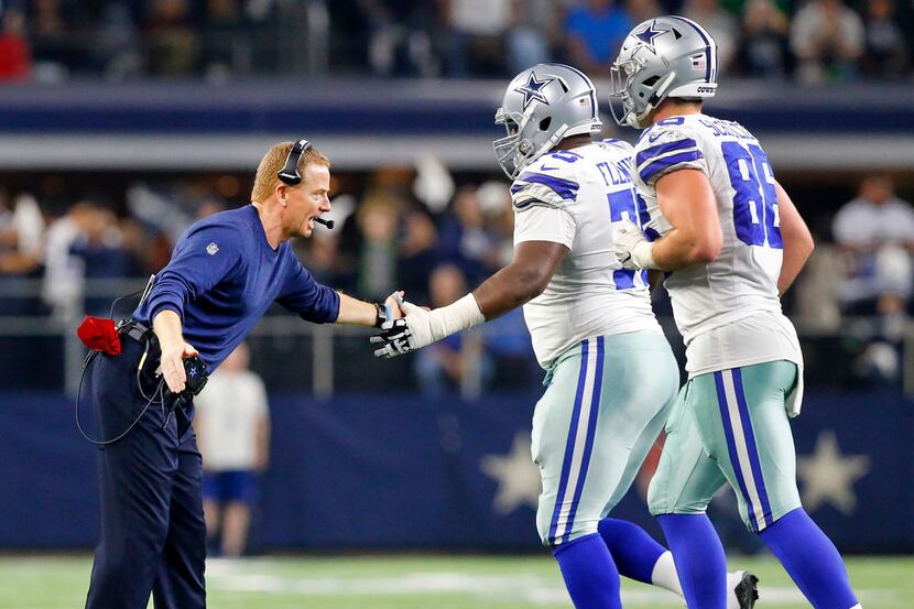 Dallas Cowboys head coach Jason Garrett slaps hands with offensive tackle Cameron Fleming...