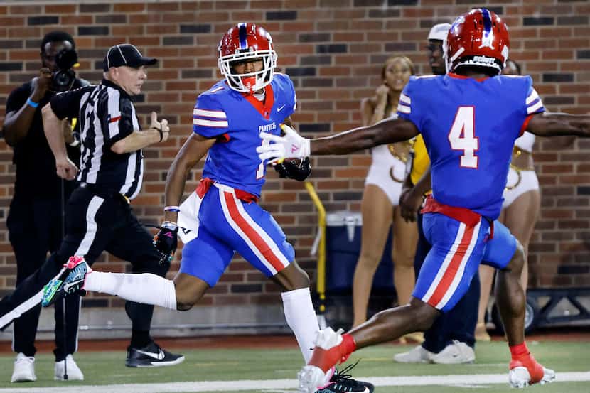 Duncanville wide receiver Dakorien Moore (1) looks over his shoulder as he carries the ball...