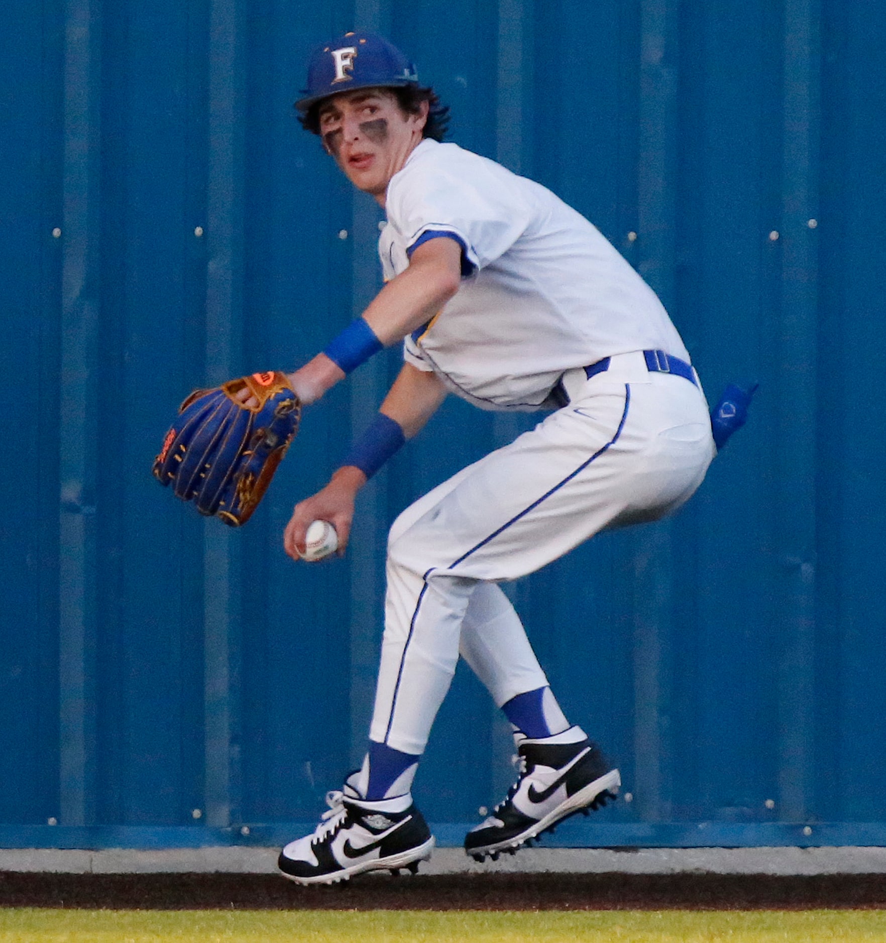 Frisco center fielder Jimmy Catalano (8) throws  the ball back to the infield from the fence...