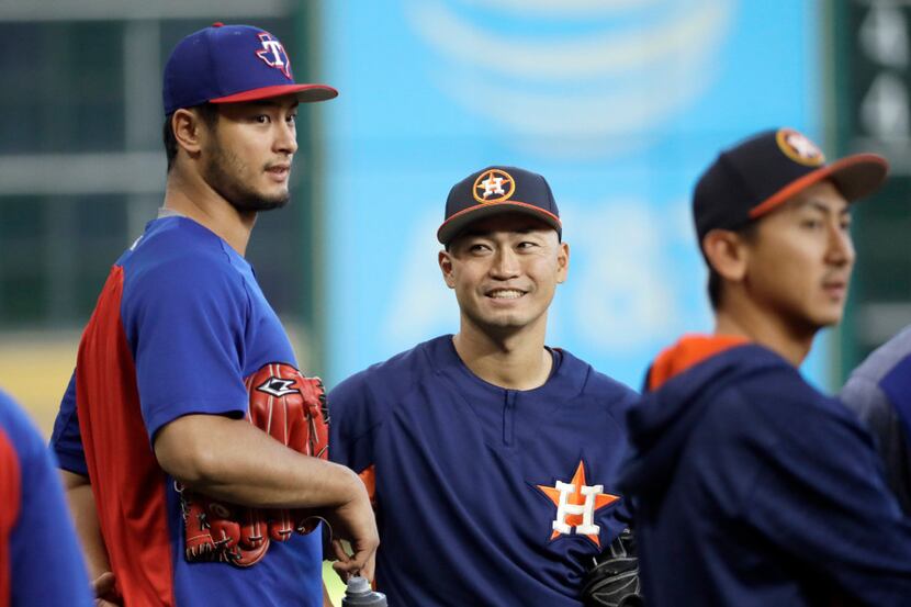 Houston Astros left fielder Norichika Aoki, right, talks with Texas Rangers pitcher Yu...