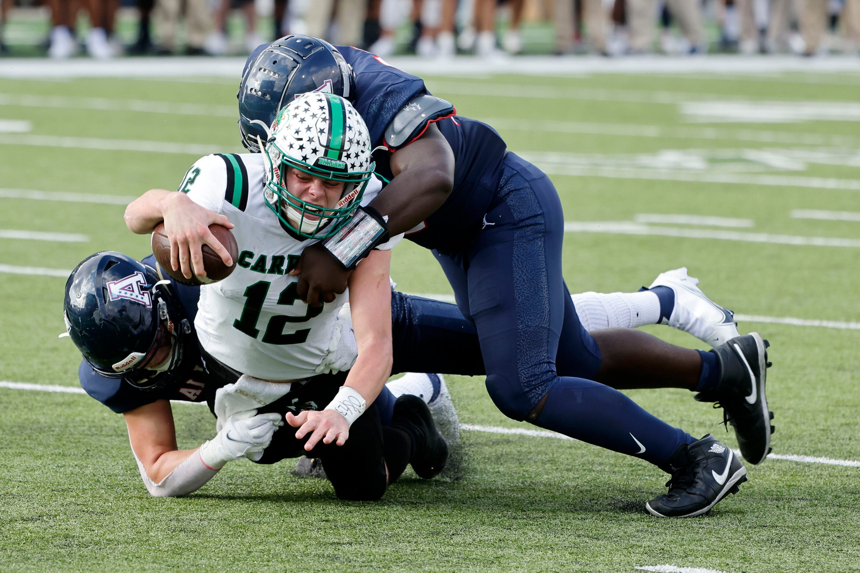 Allen’s Aidan Graham, left, and DJ Hicks, top, tackle Southlake quarterback Kaden Anderson...