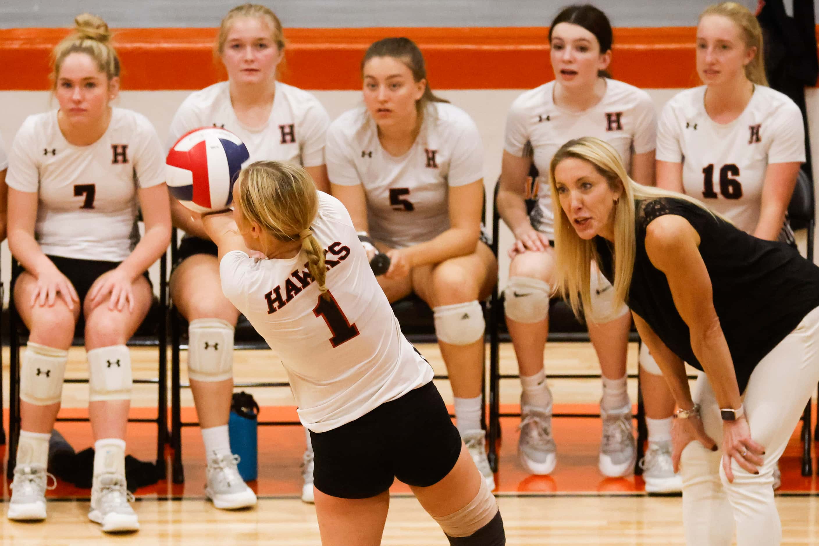 Rockwall Heath’s Reagan Ruecker (left) digs the ball as head coach Maggie Younger instructs...