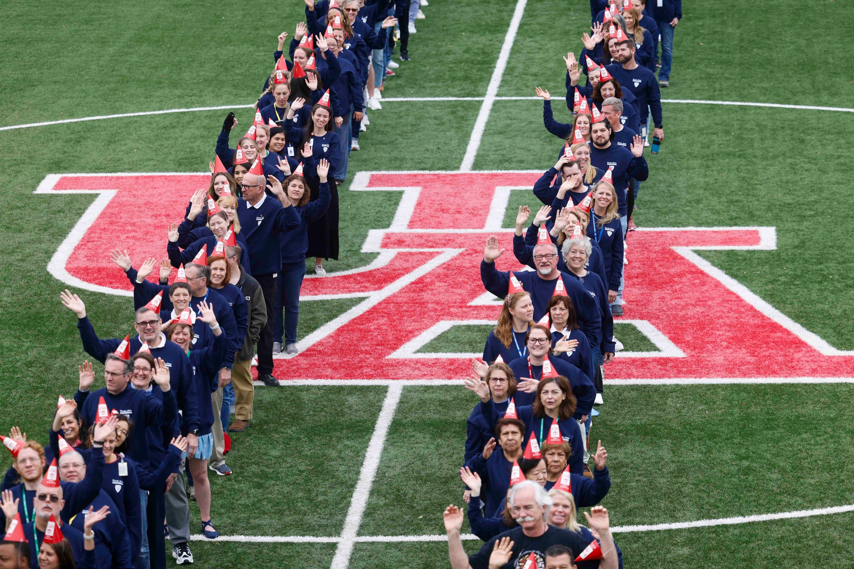 Students and faculties wave while standing in formation of "UA 150" for a giant group photo...