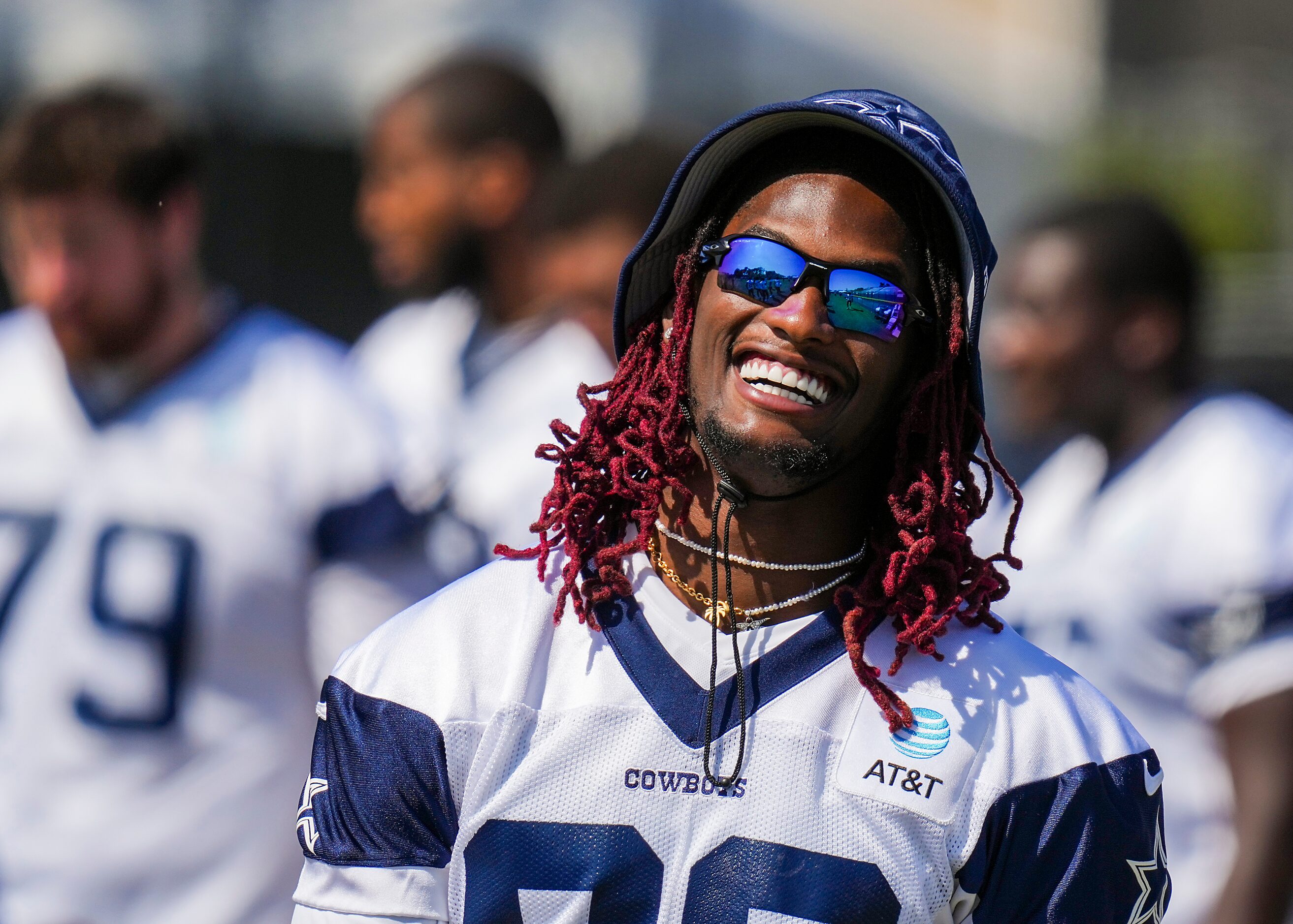 Dallas Cowboys wide receiver CeeDee Lamb laughs with teammates during a training camp...