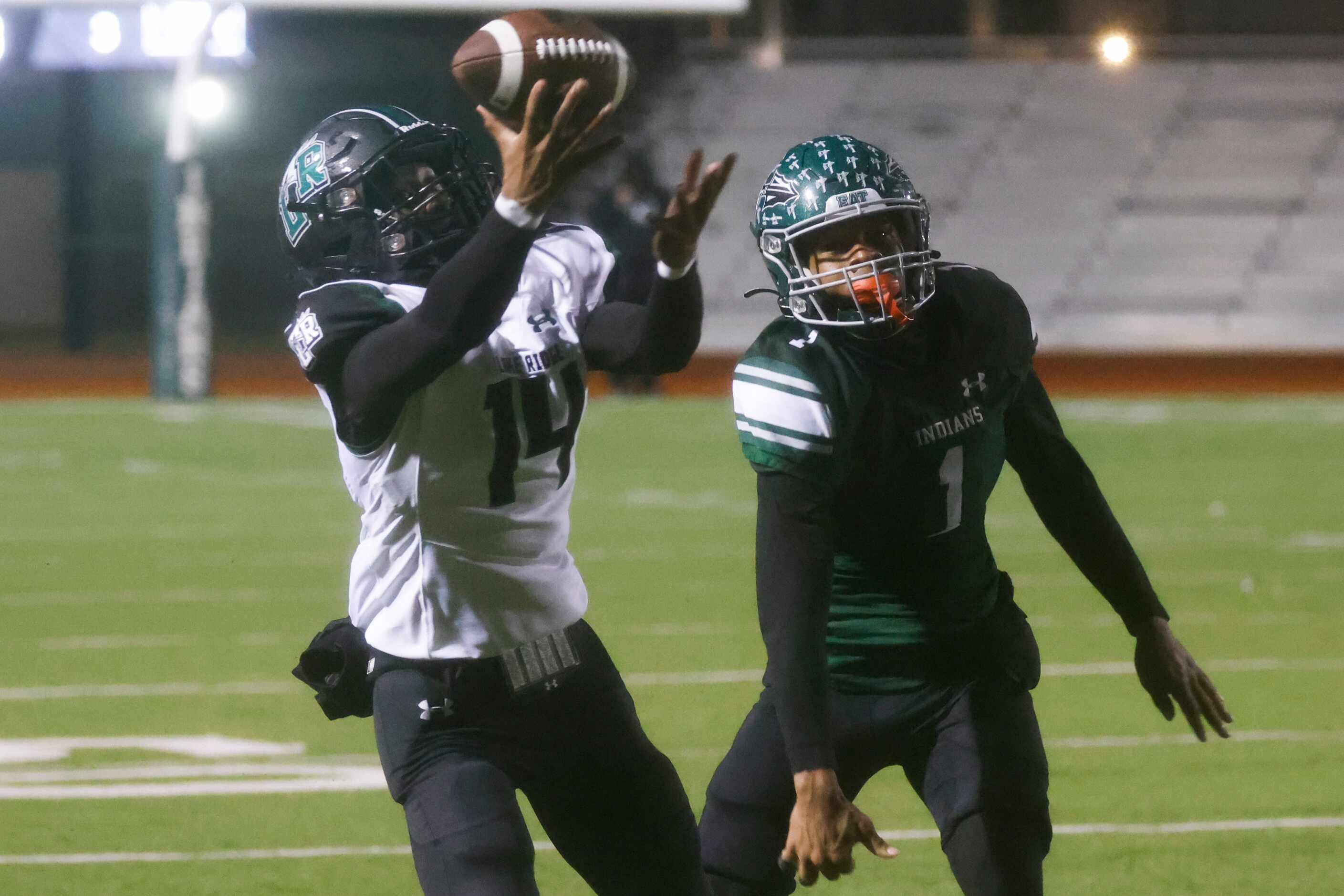 Mansfield Lake Ridge High’s Jamaal Hall (14) receives a pass past Waxahachie’s Keith Abney...