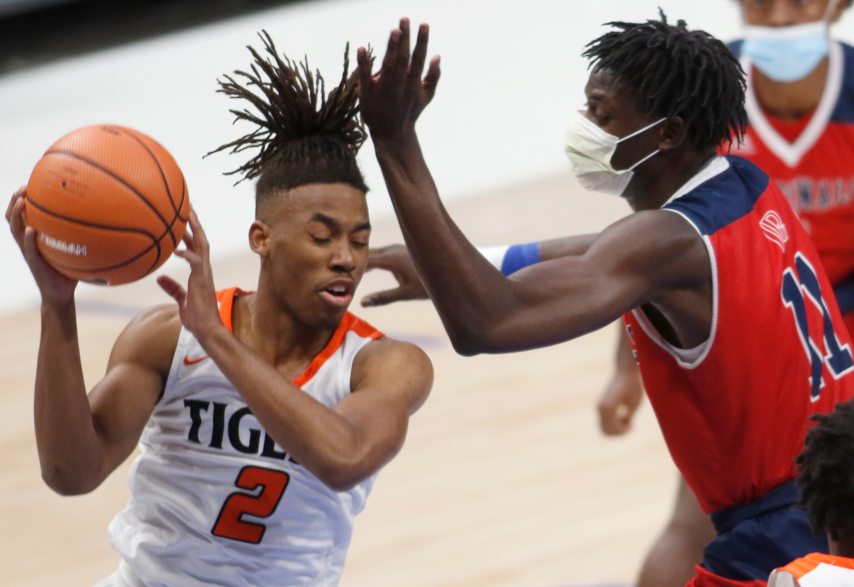 Lancaster's Dorien Goodman (2) pulls down a rebound and clears the pursuit of Plano John...