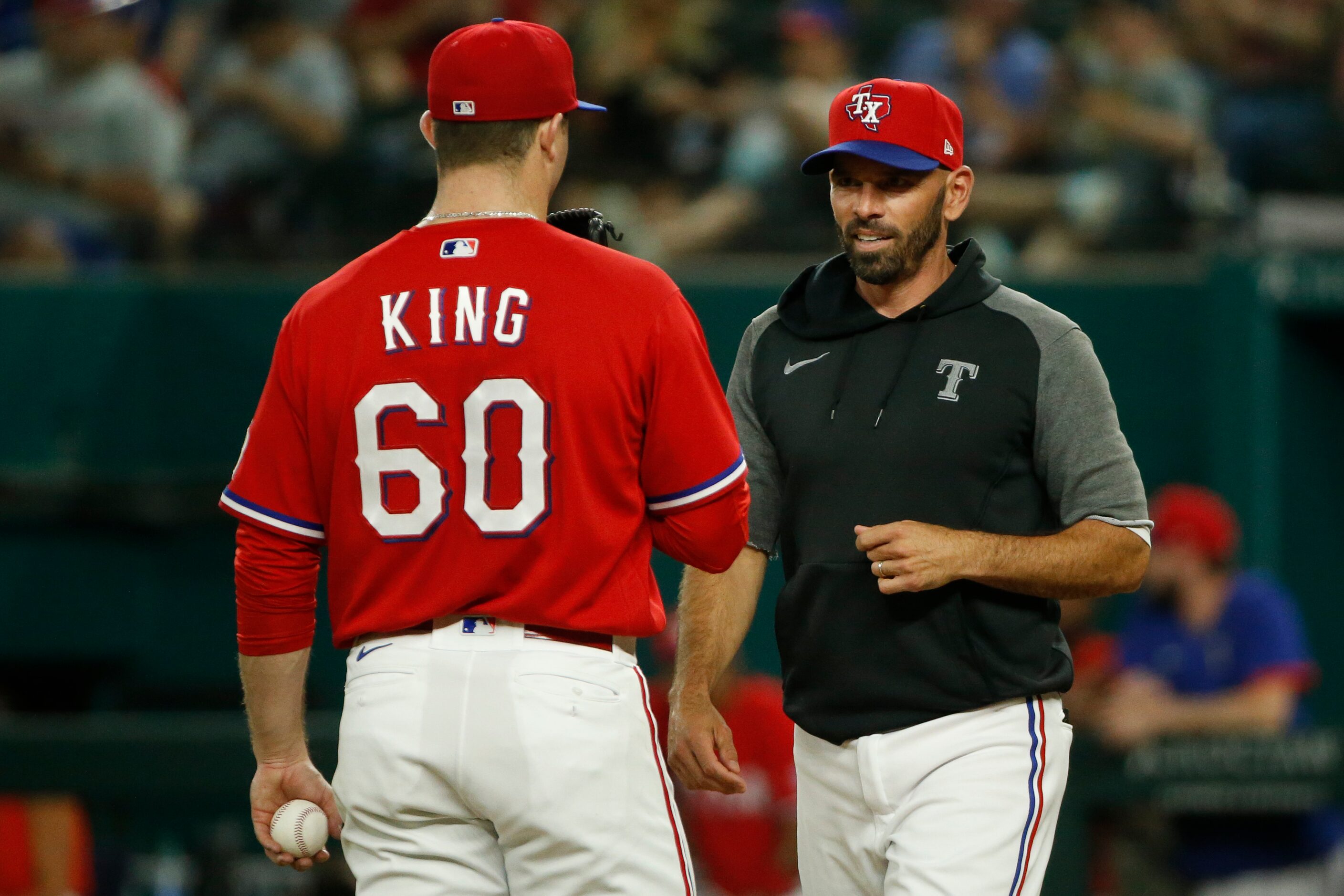 Texas Rangers relief pitcher John King (60) talks with Texas Rangers manager Chris Woodward...