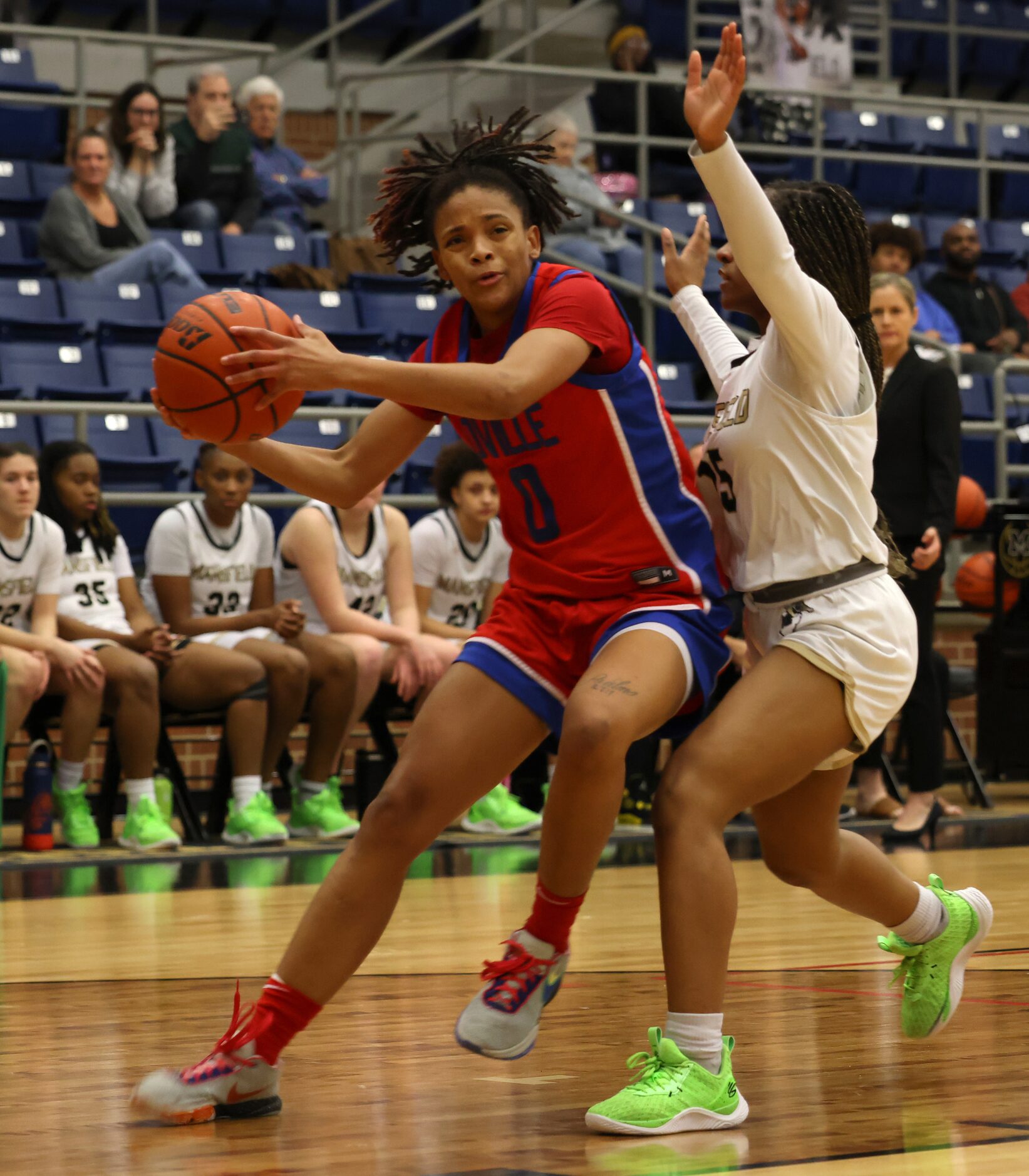 Duncanville guard Chloe Mann (0) drives to the basket as she is defended by Mansfield guard...