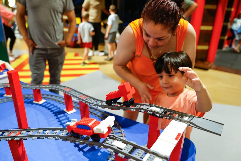 Juan Sifuentes, 4, with his mother Mari Coria, releases a lego train on the track, on...