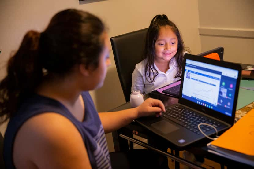 Hebreny Cojulum, 19, attends a class virtually while sister Daysha Cojulum, 5, watches...